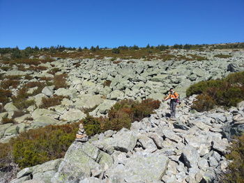 High angle view of man standing on rocky landscape against clear sky
