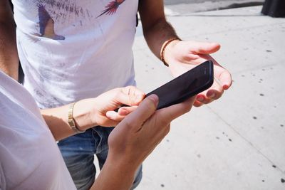 Midsection of woman holding mobile phone