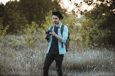 Full length of young man standing against trees