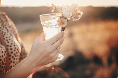 Midsection of woman holding drink outdoors