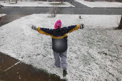 Rear view of woman standing in snow