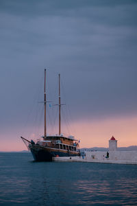 Sailboat sailing on sea against sky during sunset