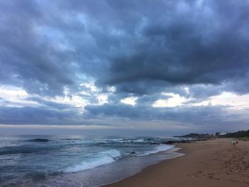 View of beach against cloudy sky