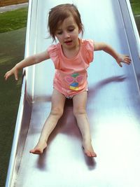 Full length of girl enjoying on slide at park
