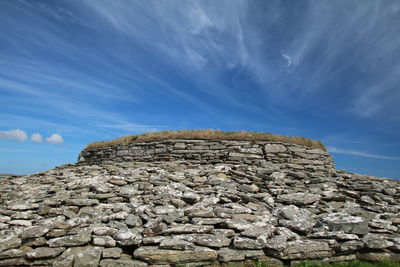 Low angle view of rocks against blue sky