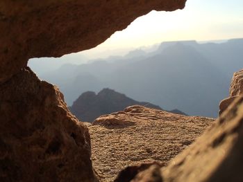 Silhouette of mountains through brown rocks