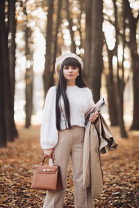 Young woman using phone while standing on land