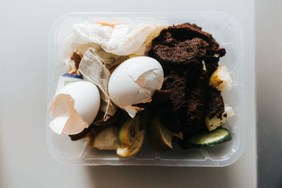 High angle view of organic waste in a small plastic box on table 