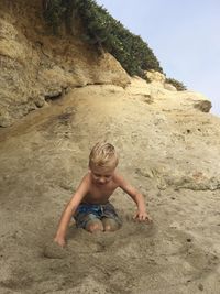 Boy playing on sand at beach