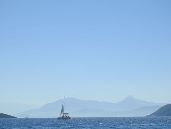 Sailboat in sea against clear sky