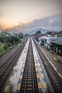 Railroad tracks against sky during sunset