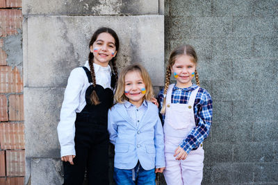 Cute girls standing against wall