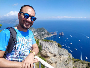 Portrait of smiling man wearing sunglasses against sea