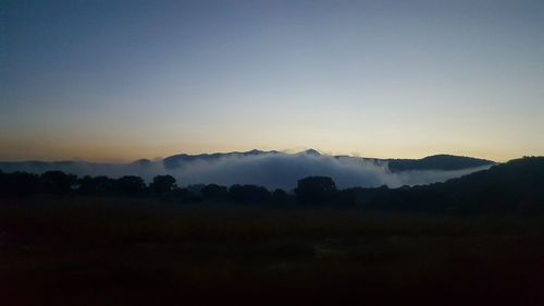 Scenic view of silhouette mountains against sky at sunset