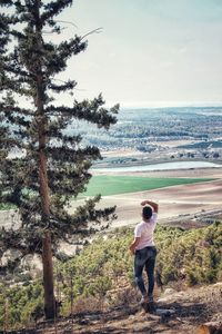 Rear view of woman standing against landscape