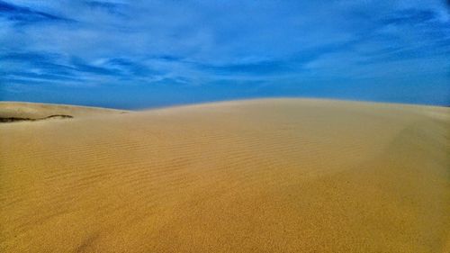 Scenic view of desert against blue sky