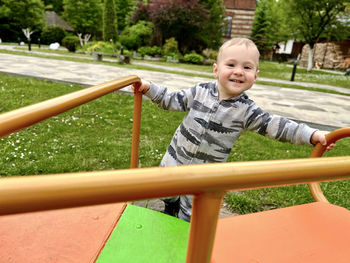 Happy toddler boy rides on a swing. indoor playground. a cute boy of one and a half years. 