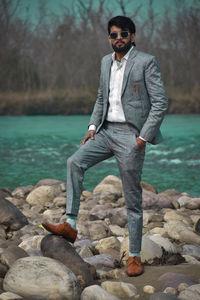 Portrait of young man standing by lake