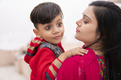 Mother and son embracing while standing outdoors