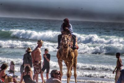 People at beach against sky