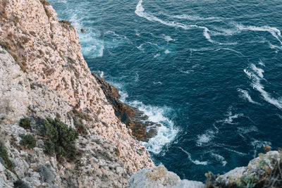 High angle view of rocks on sea shore