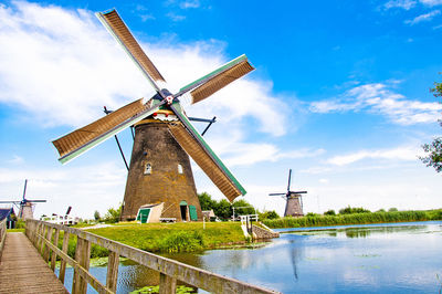 Traditional windmill on landscape against sky