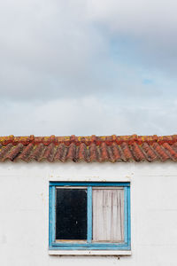 Low angle view of house against sky. low angle view of window of old building against sky 