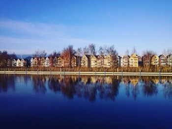 Reflection of trees in lake against clear blue sky