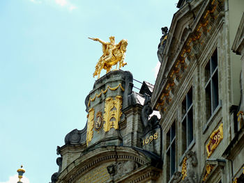 Low angle view of statue of historic building against sky