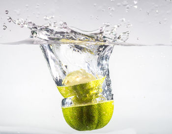 Close-up of water splashing in glass against white background