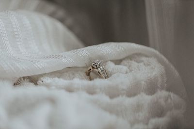 Close-up of wedding diamond ring on white fabric