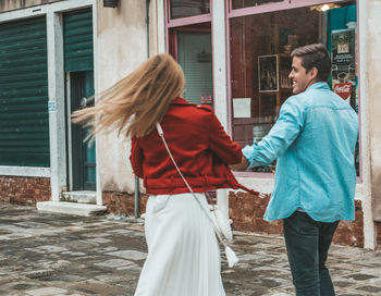 Rear view of couple standing against building