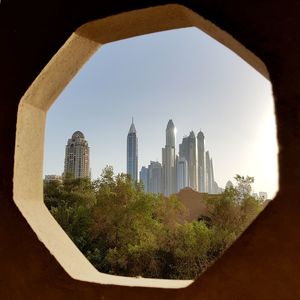 View of cityscape against clear sky seen through arch