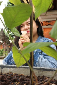 Portrait of woman drinking from leaves