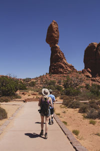 Rear view of friends walking in arches national park