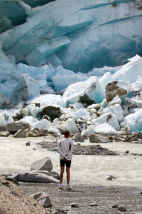 Rear view of man standing in frozen lake