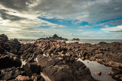 Rocky sea beach with crashing waves at morning from flat angle