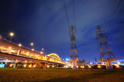 Low angle view of illuminated bridge against sky at night