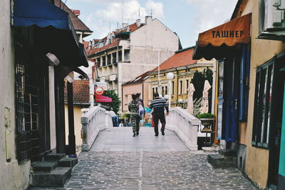 Man walking in city against sky