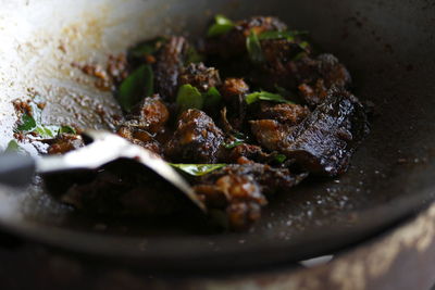 Cooking thai cuisine, spicy catfish with red curry paste on a hot wok frying pan 