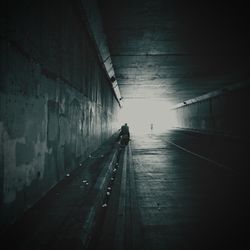 Rear view of man walking in tunnel
