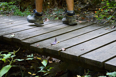 Low section of man standing on boardwalk