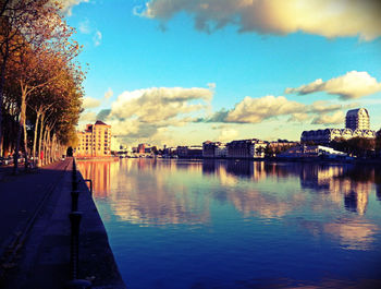 River amidst buildings in city against sky