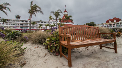 Built structure on beach by houses against sky