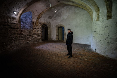 Rear view of man walking in tunnel