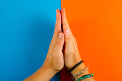 Close-up of woman hand against orange background