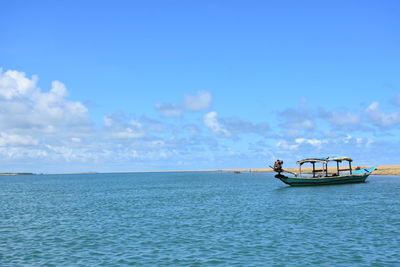 Boat sailing in sea against blue sky