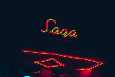 Low angle view of illuminated neon sign at night