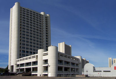 Low angle view of modern buildings against blue sky