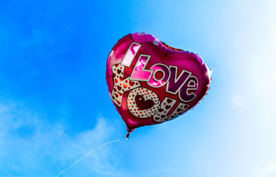 Low angle view of heart shape against blue sky